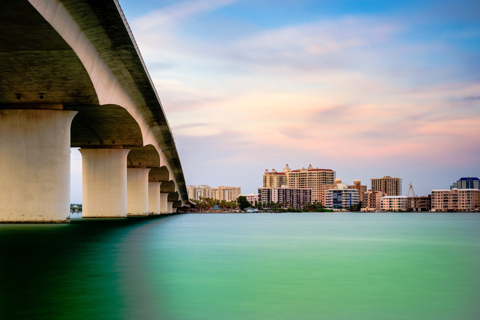 A bridge over a body of water with a city in the background.